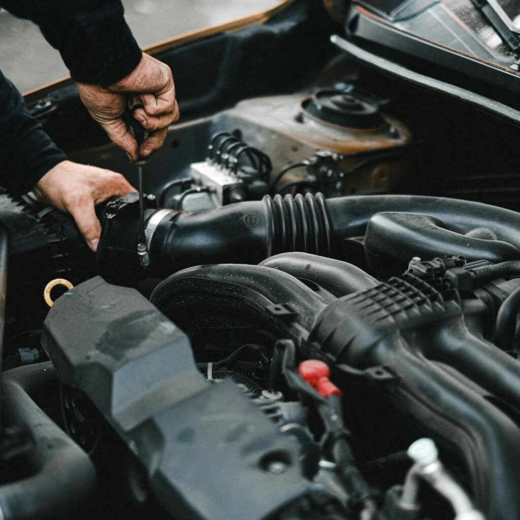  An ASE Certified mechanic inspecting the engine of a modern Audi in a clean workshop.